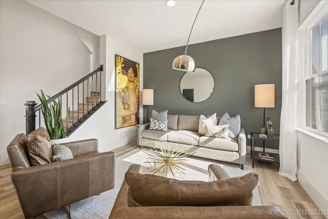 a living room with furniture wooden floor and a large window