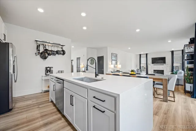 a kitchen with white cabinets appliances and wooden floor