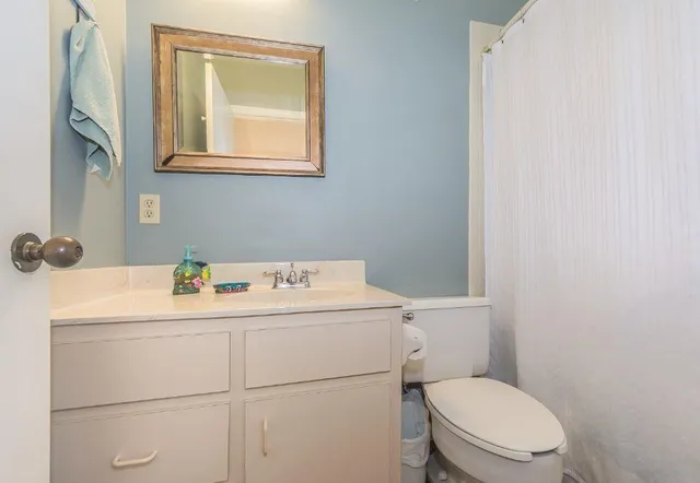a bathroom with a sink mirror vanity and toilet