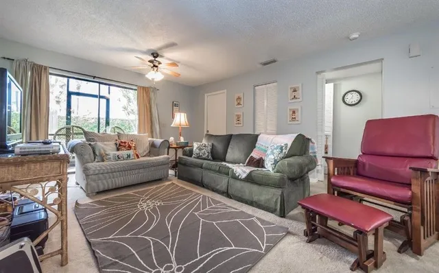 a living room with furniture a large window and a chandelier