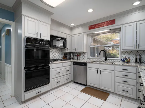 a kitchen with granite countertop a stove sink and cabinets
