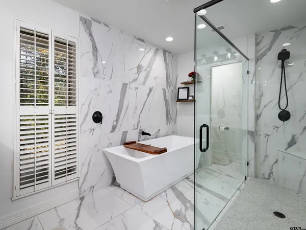 a bathroom with a tub a window and a shower