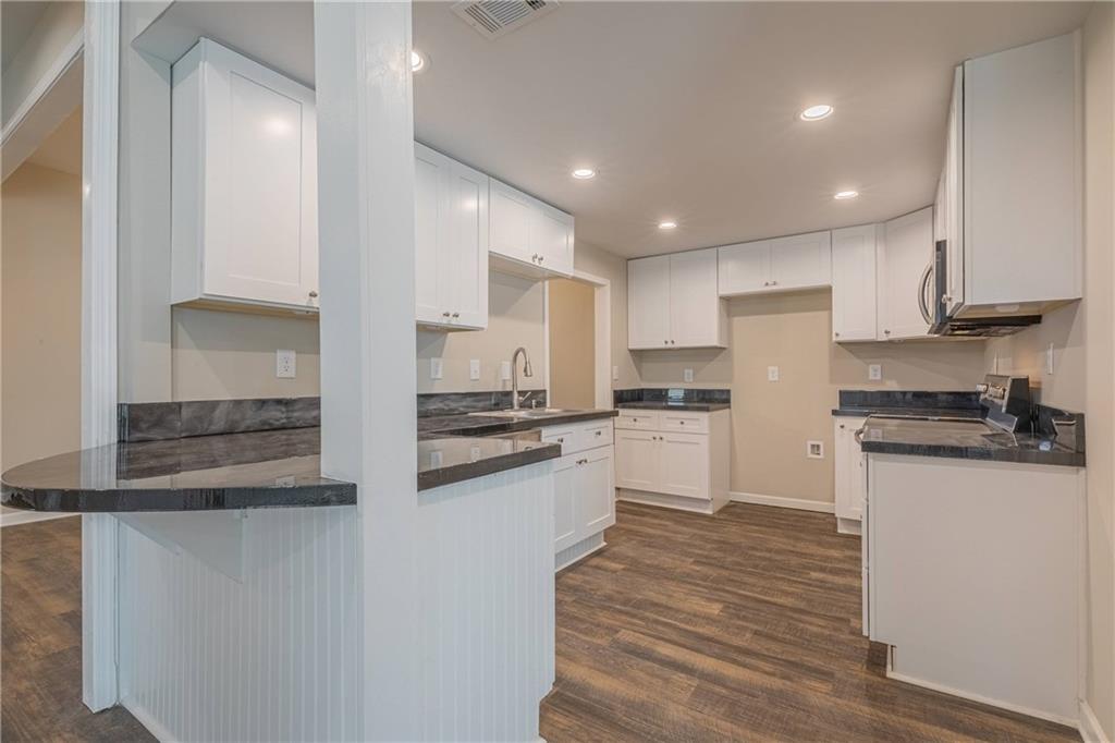 3107 Hendrix Circle Southwest Covington, GA 30014 - Photo 20 of 66 a kitchen with stainless steel appliances granite countertop a stove a sink and a refrigerator