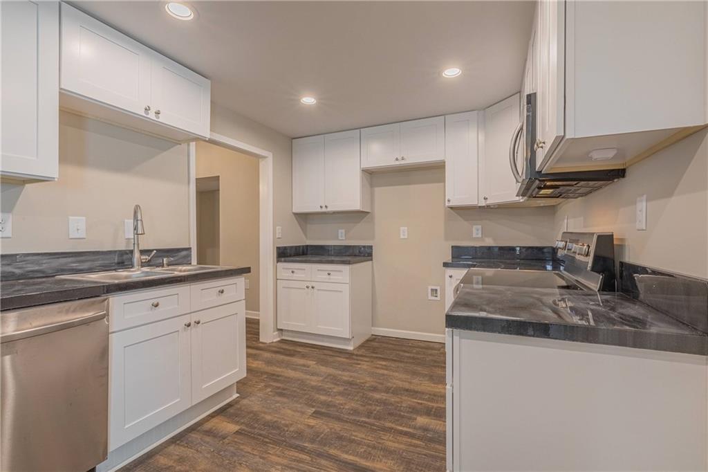 3107 Hendrix Circle Southwest Covington, GA 30014 - Photo 21 of 66 a kitchen with stainless steel appliances granite countertop a sink stove and refrigerator