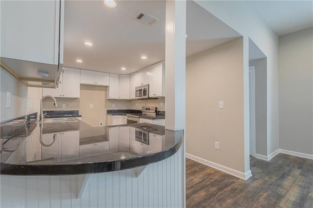 3107 Hendrix Circle Southwest Covington, GA 30014 - Photo 24 of 66 a kitchen with stainless steel appliances granite countertop a sink a stove and a refrigerator