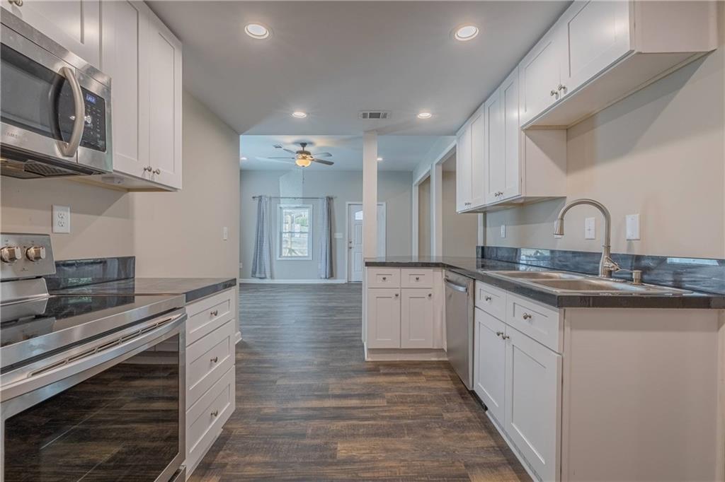 3107 Hendrix Circle Southwest Covington, GA 30014 - Photo 27 of 66 a kitchen with stainless steel appliances granite countertop a sink and cabinets