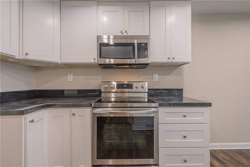 3107 Hendrix Circle Southwest Covington, GA 30014 - Photo 28 of 66 a kitchen with granite countertop white cabinets and stainless steel appliances