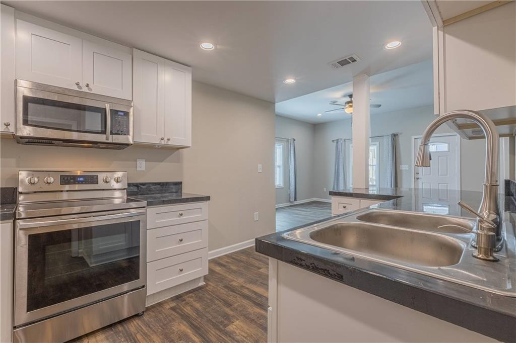 3107 Hendrix Circle Southwest Covington, GA 30014 - Photo 29 of 66 a kitchen with granite countertop a sink stainless steel appliances and cabinets