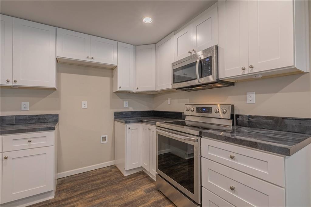 3107 Hendrix Circle Southwest Covington, GA 30014 - Photo 30 of 66 a kitchen with stainless steel appliances granite countertop a stove a microwave and cabinets