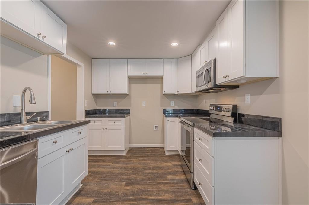 3107 Hendrix Circle Southwest Covington, GA 30014 - Photo 32 of 66 a kitchen with stainless steel appliances granite countertop a sink and cabinets