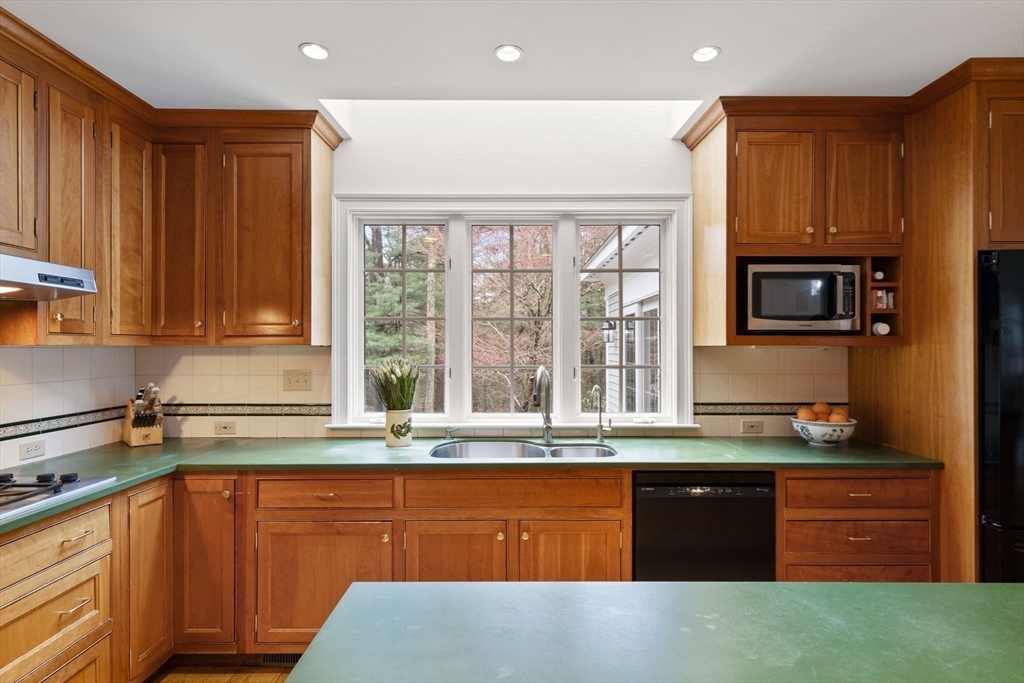 5 Powisset Street Dover, MA 02030 - Photo 13 of 41 a kitchen with granite countertop wooden cabinets a stove and a sink