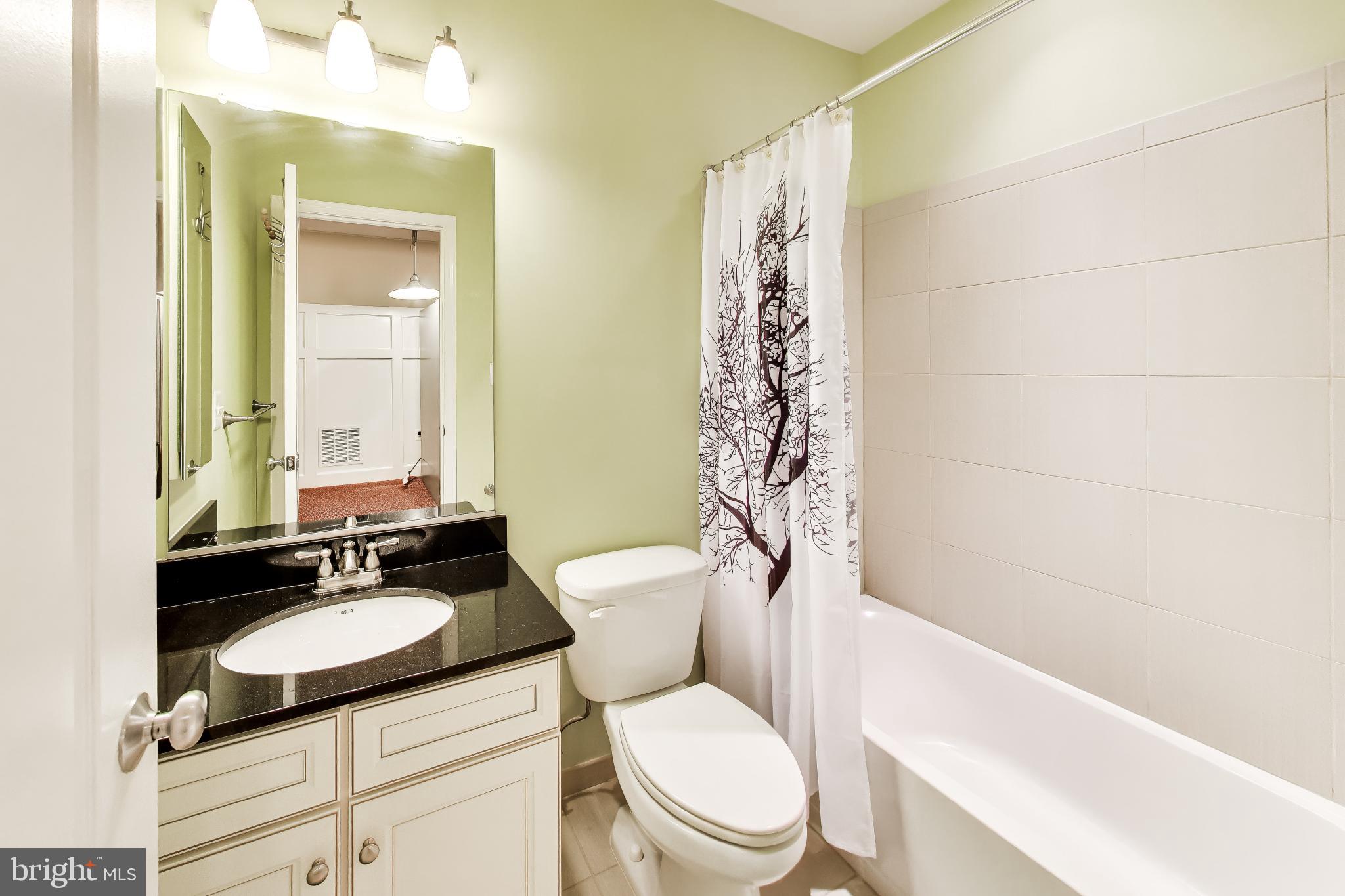 13513 Moonlight Trail Drive Silver Spring, MD 20906 - Photo 54 of 78 a bathroom with a granite countertop sink toilet a mirror and shower
