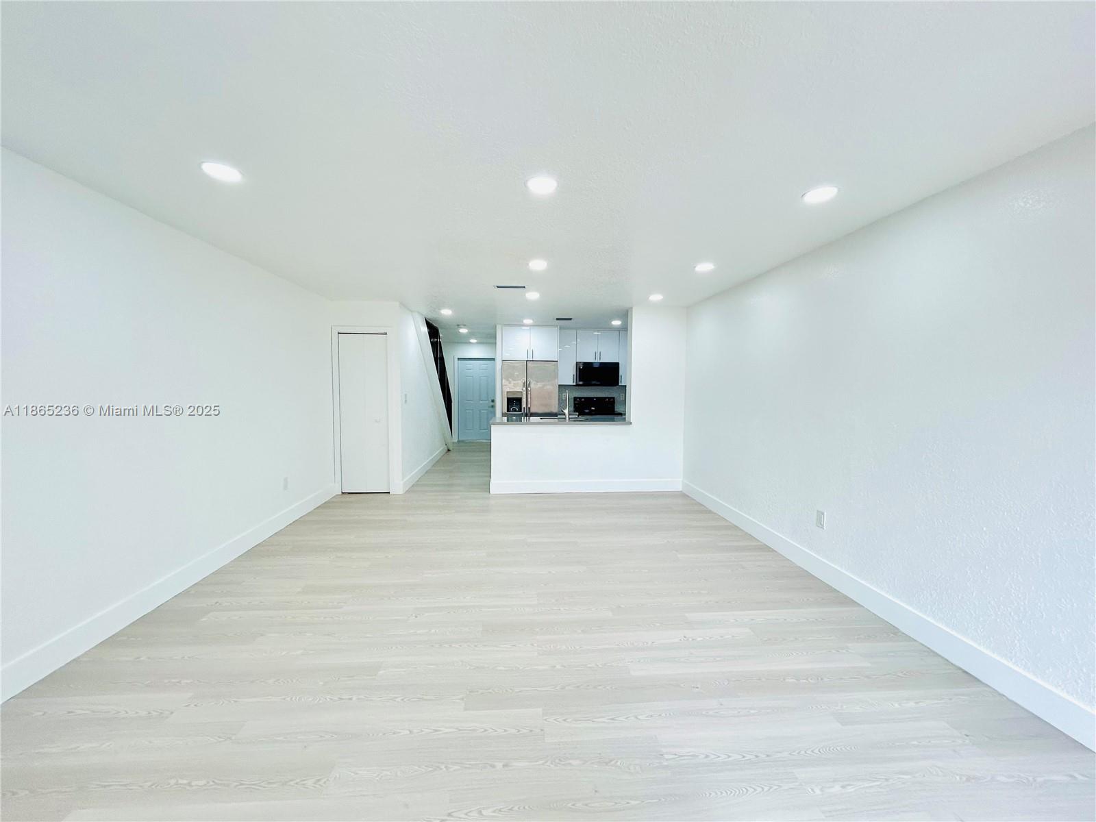 a view of a kitchen with a sink and a refrigerator