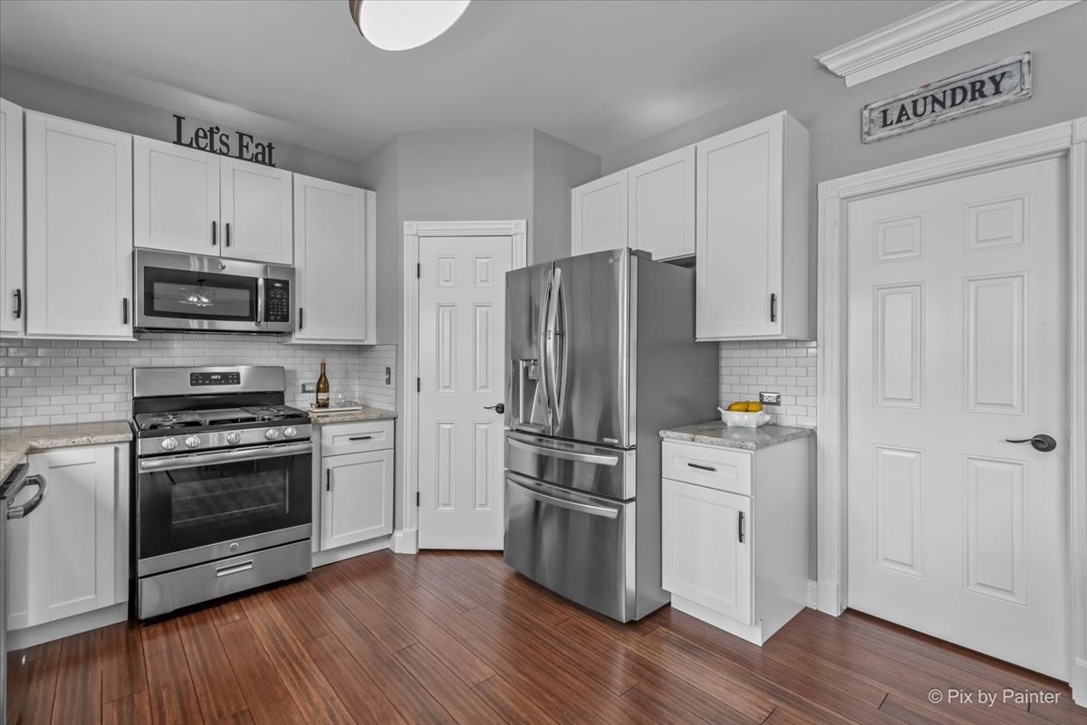 313 Market Street Genoa, IL 60135 - Photo 17 of 49 a kitchen with cabinets stainless steel appliances and wooden floor