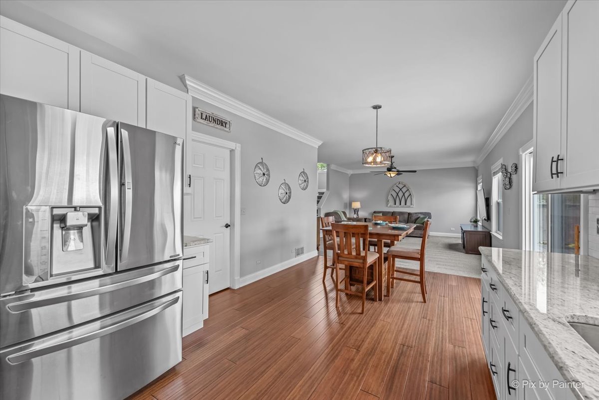 313 Market Street Genoa, IL 60135 - Photo 18 of 49 a kitchen with stainless steel appliances a dining table chairs refrigerator and wooden floor
