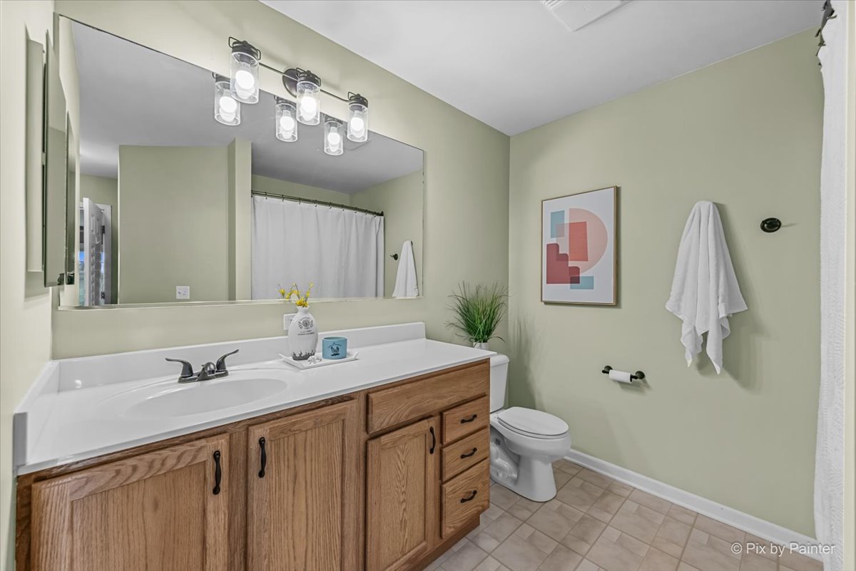 313 Market Street Genoa, IL 60135 - Photo 21 of 49 a bathroom with a sink a toilet a mirror a vanity and shower