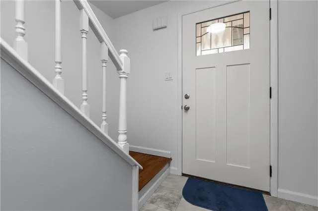 a view of empty room with wooden floor and kitchen