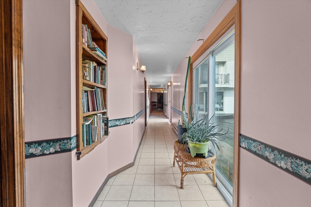 186 8 Lots Road Sutton, MA 01590 - Photo 17 of 33 a hallway with a book shelf and flower pot