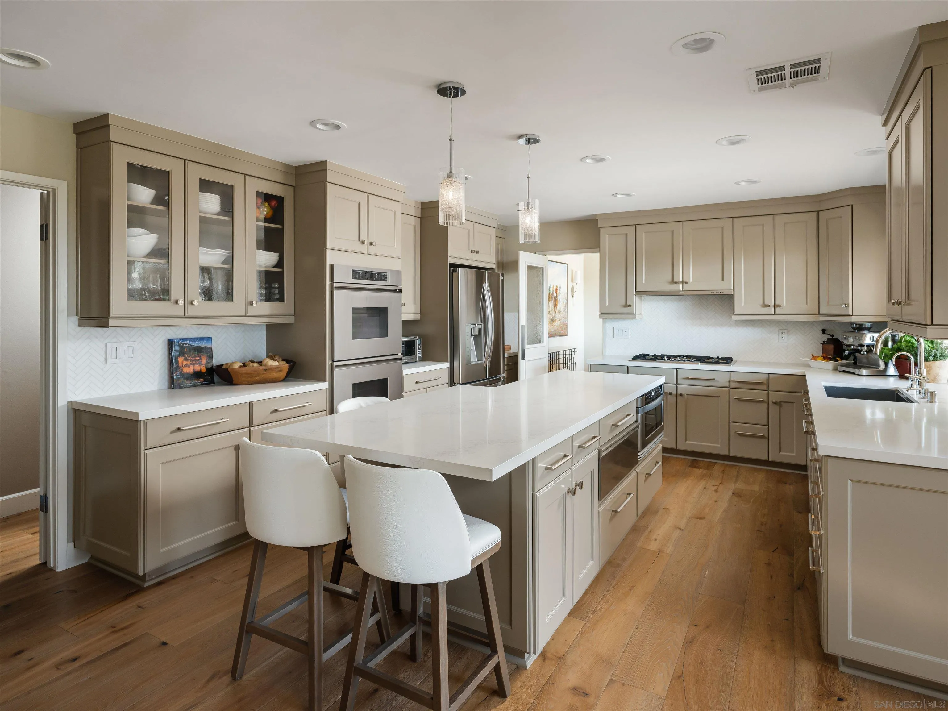 17136 El Mirador Rancho Santa Fe, CA 92067 - Photo 25 of 58 a kitchen with stainless steel appliances granite countertop a stove a sink dishwasher a microwave oven and a dining table with wooden floor