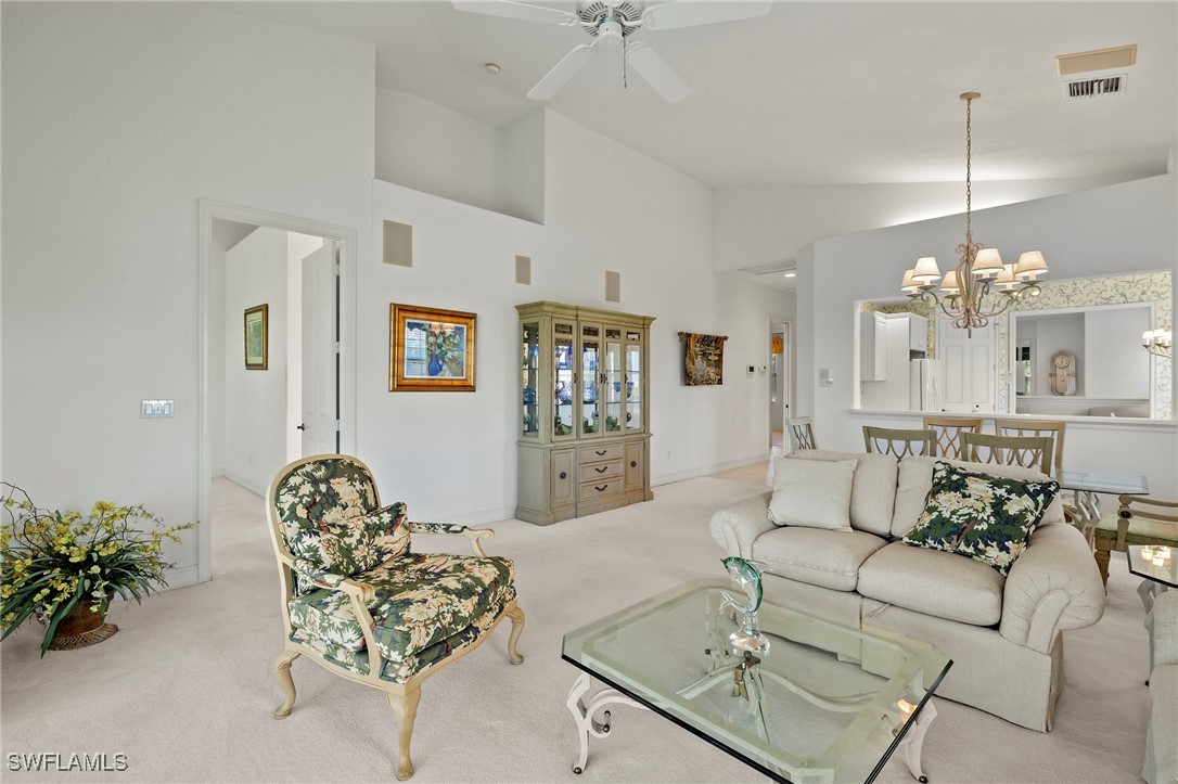 6035 Trophy Drive, Unit 103 Naples, FL 34110 - Photo 11 of 44 a living room with furniture flowers and a chandelier