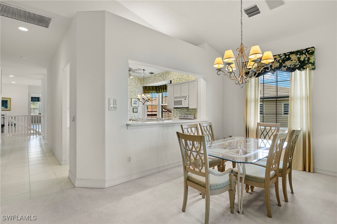 6035 Trophy Drive, Unit 103 Naples, FL 34110 - Photo 14 of 44 a view of a dining room with furniture wooden floor and chandelier