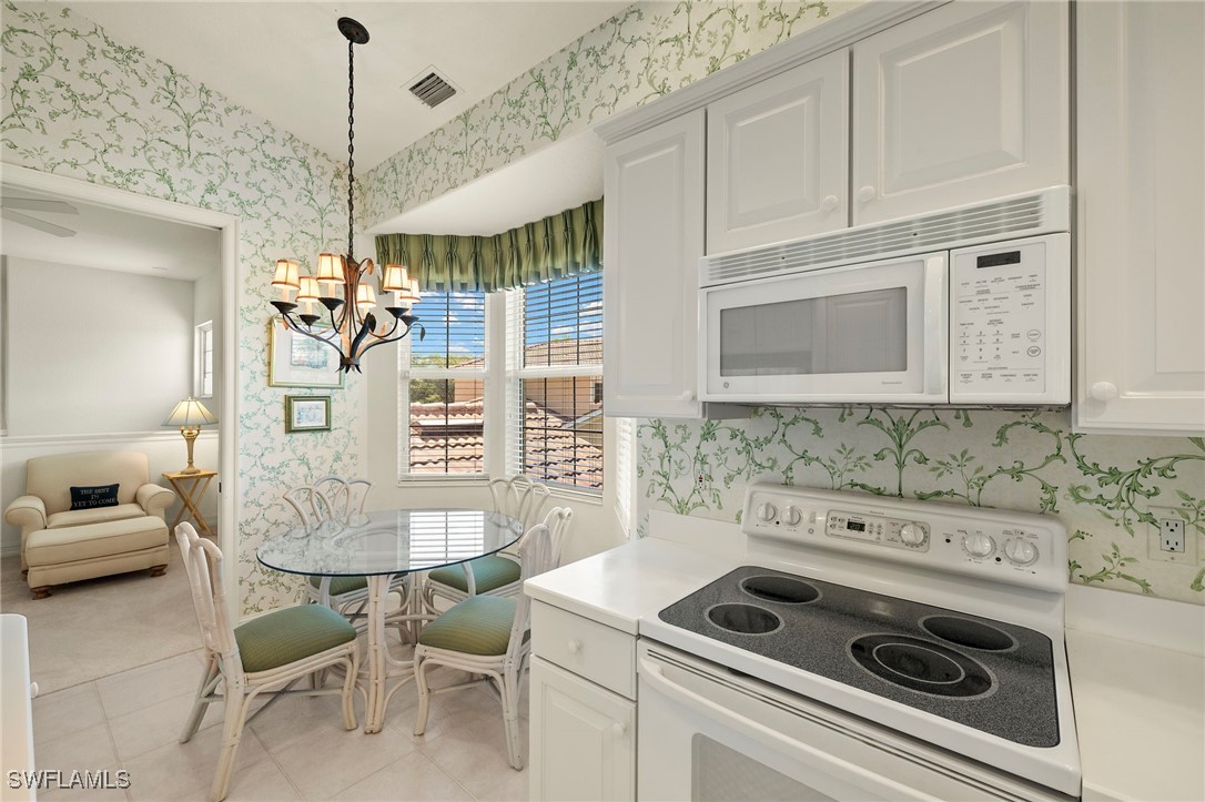 6035 Trophy Drive, Unit 103 Naples, FL 34110 - Photo 15 of 44 a kitchen that has a stove and a microwave