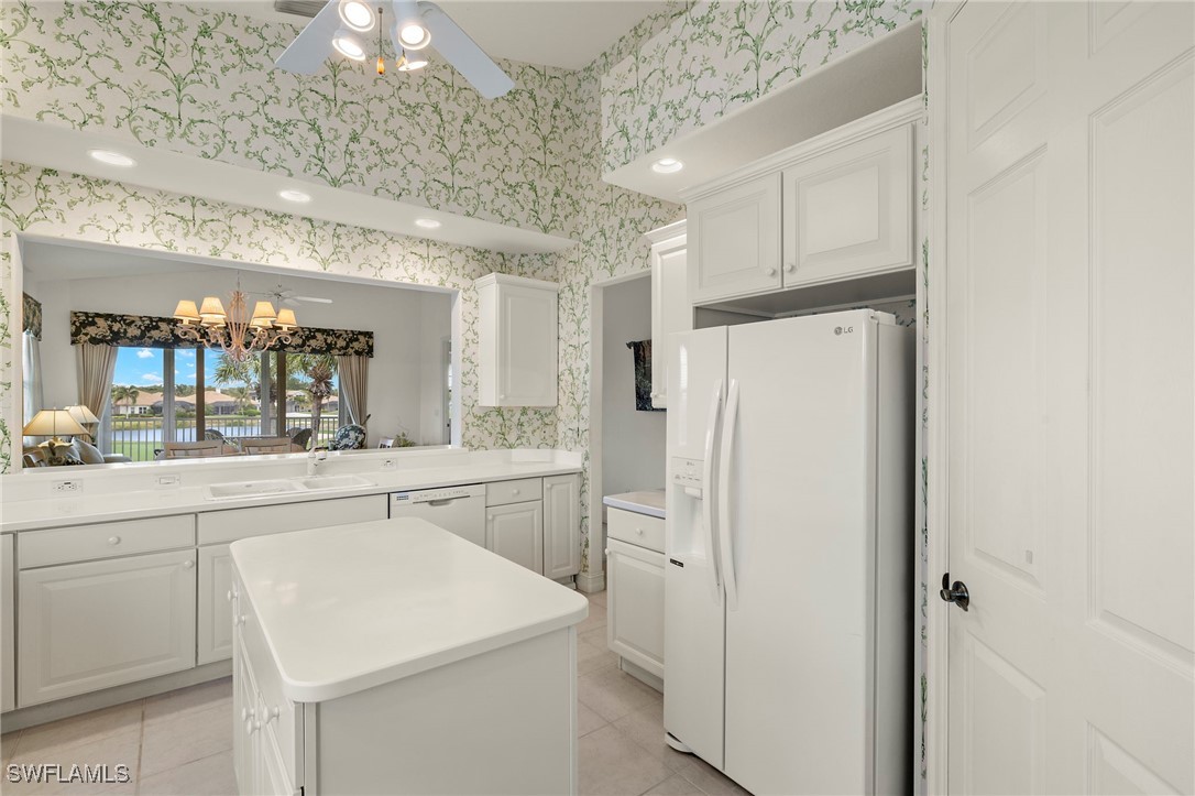6035 Trophy Drive, Unit 103 Naples, FL 34110 - Photo 18 of 44 a kitchen with white cabinets and white appliances