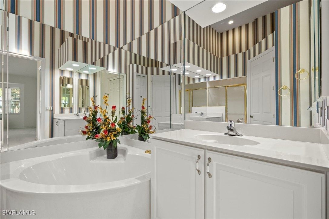 6035 Trophy Drive, Unit 103 Naples, FL 34110 - Photo 25 of 44 a bathroom with a sink a mirror and a bathtub