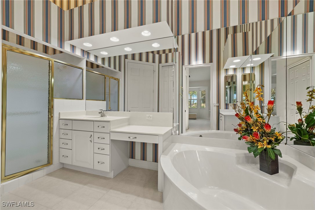 6035 Trophy Drive, Unit 103 Naples, FL 34110 - Photo 26 of 44 a bathroom with a tub sink and mirror