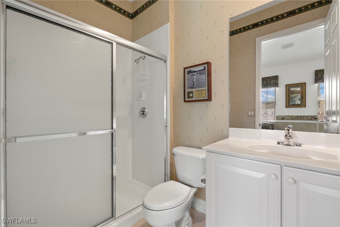 6035 Trophy Drive, Unit 103 Naples, FL 34110 - Photo 29 of 44 a bathroom with a granite countertop sink mirror vanity and toilet