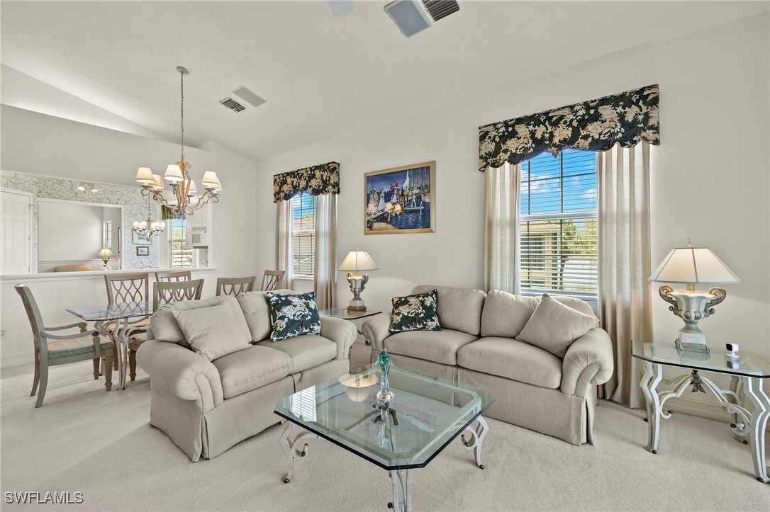 6035 Trophy Drive, Unit 103 Naples, FL 34110 - Photo 7 of 44 a living room with furniture a chandelier and a window