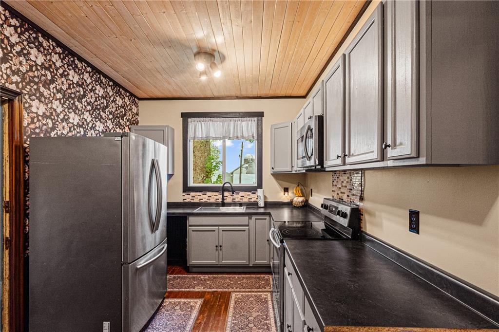 580 Green Valley Road Eighty Four, PA 15330 - Photo 15 of 45 a kitchen with stainless steel appliances granite countertop a refrigerator a sink dishwasher a stove and white countertops with wooden floor