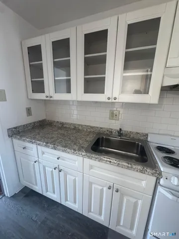 a kitchen with granite countertop a sink and a stove
