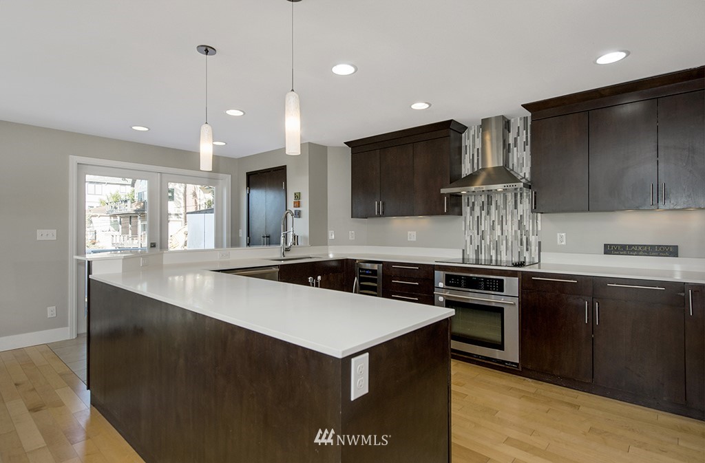 710 West Howe Street Seattle, WA 98119 - Photo 11 of 40 a kitchen with kitchen island granite countertop a sink a stove and a refrigerator