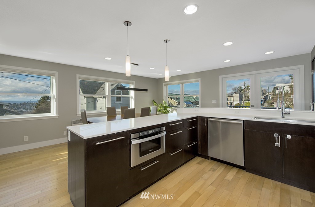 710 West Howe Street Seattle, WA 98119 - Photo 12 of 40 a kitchen with stainless steel appliances granite countertop a stove a sink and a microwave