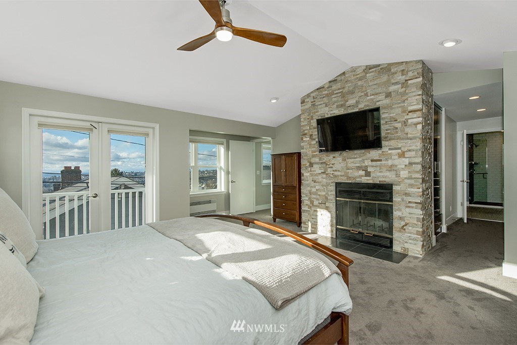 710 West Howe Street Seattle, WA 98119 - Photo 18 of 40 a spacious bedroom with a bed and a flat screen tv