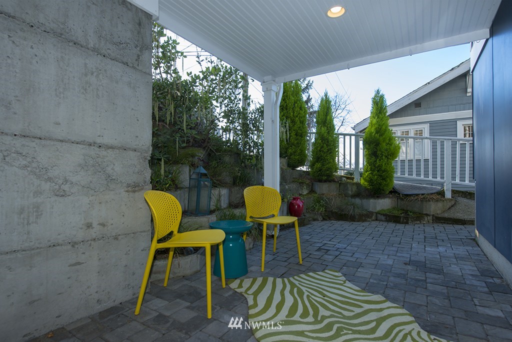 710 West Howe Street Seattle, WA 98119 - Photo 28 of 40 a view of a patio with table and chairs potted plants with wooden floor
