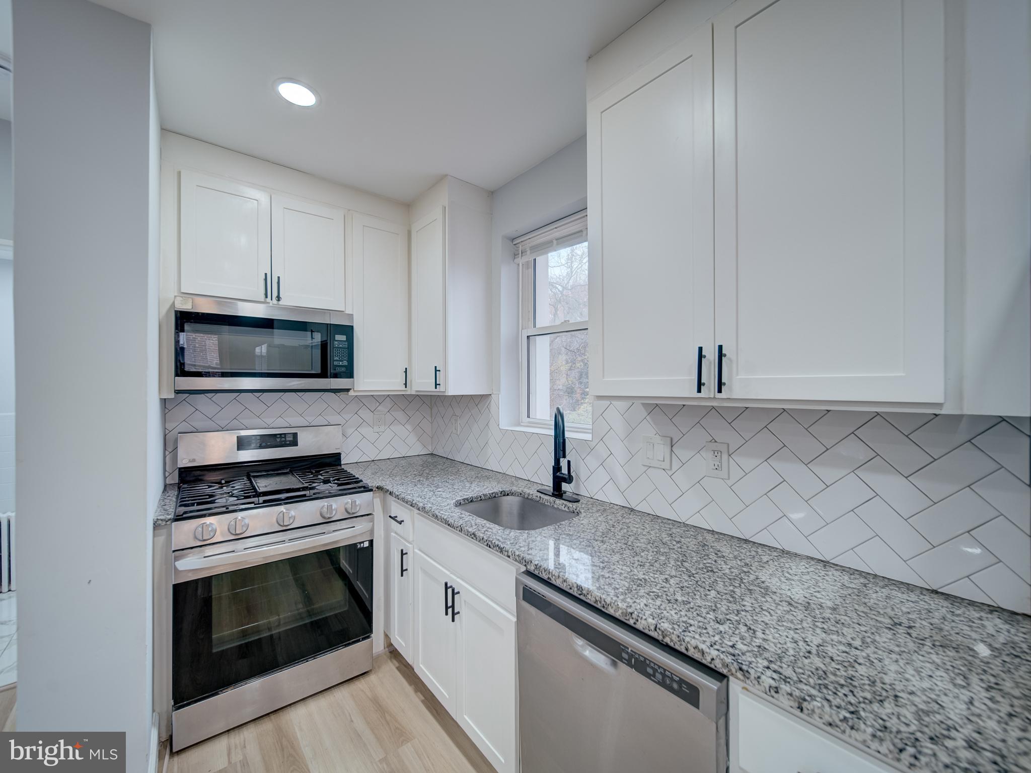 4308 Alabama Avenue Southeast Washington, DC 20019 - Photo 20 of 47 a kitchen with granite countertop a sink cabinets and stainless steel appliances