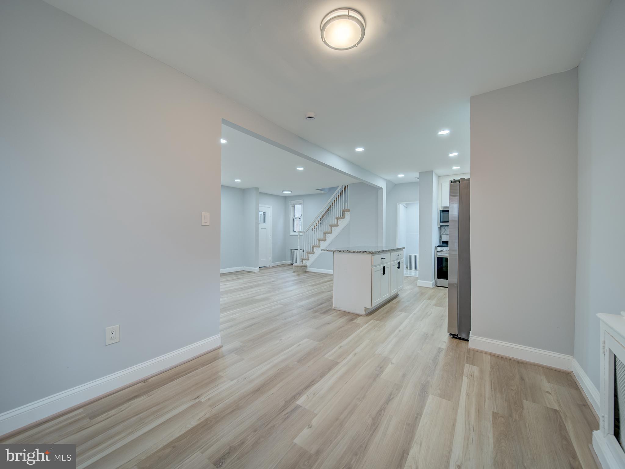 4308 Alabama Avenue Southeast Washington, DC 20019 - Photo 23 of 47 an empty room with wooden floor and kitchen view