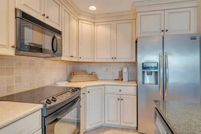 a kitchen with stainless steel appliances white cabinets and a stove top oven