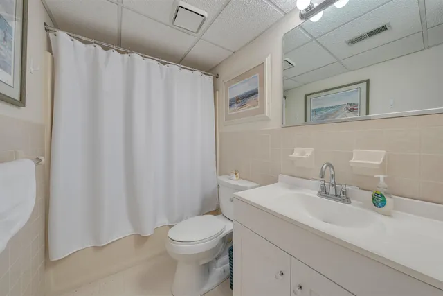 a bathroom with a sink a toilet and shower curtain