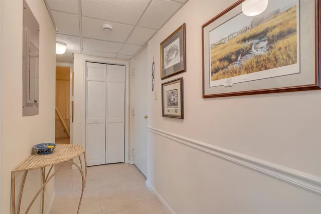 a view of a hallway with white walls and cabinet