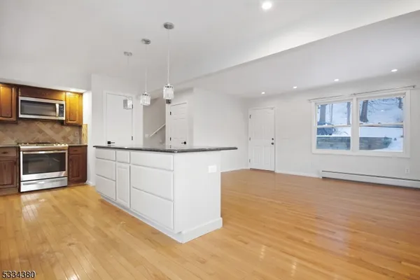 a kitchen with stainless steel appliances kitchen island granite countertop a stove a sink and a refrigerator