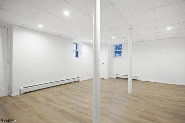 an empty room with wooden floor and white walls
