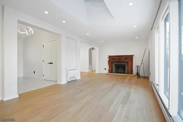 a view of empty room with wooden floor and fireplace