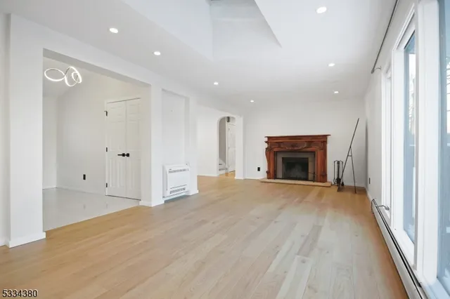 a view of empty room with wooden floor and fireplace