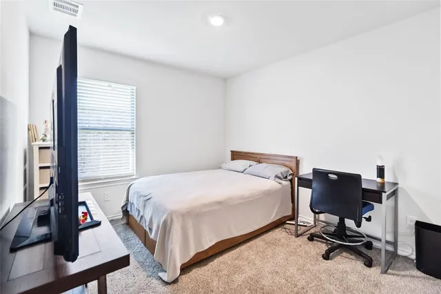 a bedroom with a bed and a desk