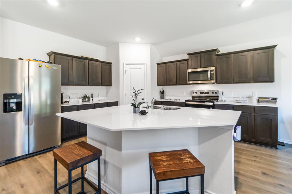 103 Mapleoak Drive Caddo Mills, TX 75135 - Photo 19 of 31 a kitchen with stainless steel appliances a stove a sink a microwave a refrigerator and cabinets
