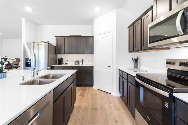 a kitchen with stainless steel appliances granite countertop a sink stove and refrigerator