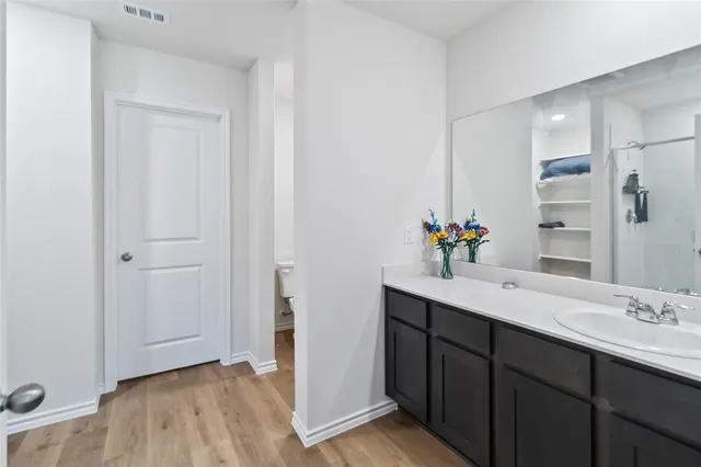a en suite bathroom with a sink double vanity granite and a mirror